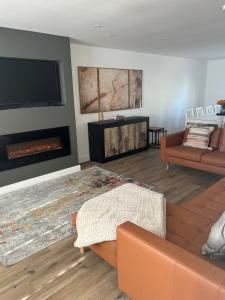 a living room with a couch and a fireplace at Garreg Fawr Trearddur Bay - Ty Oren in Trearddur