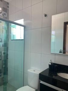 een badkamer met een toilet, een wastafel en een douche bij Casa na praia in Itanhaém