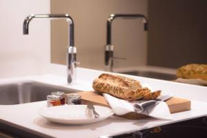 a loaf of bread on a cutting board on a kitchen counter at Modern, Luxurious 1BR Flat- Heart of Covent Garden in London