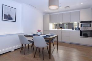 a kitchen with a dining room table and chairs at Modern, Luxurious 1BR Flat- Heart of Covent Garden in London