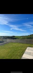 uma vista para um campo de relva ao lado de uma estrada em Garreg Fawr Trearddur Bay - Ty Oren em Trearddur