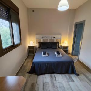 a bedroom with a bed with two phones on it at Casa Rural Sierra De Las Nieves in Tolox