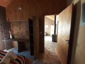 Habitación con pasillo con paredes de madera y puerta. en cabañas la arqueria candelaria en Villa Meliquina