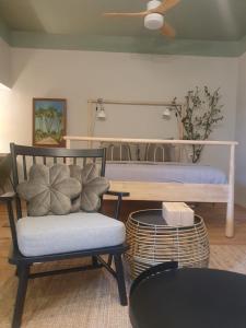 um quarto com um banco, uma cadeira e uma mesa em סוויטה על שביל הים em Atlit