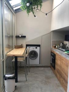 a kitchen with a table and a washing machine at סוויטה על שביל הים in Atlit +45 photos