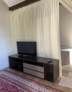 a living room with a television on a table at Flat ACM in Natal