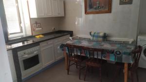 a kitchen with a table and some chairs and a stove at Casa Juan in Santa Olaja de Eslonza