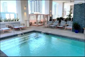 a swimming pool in a hotel lobby with chairs and tables at Downtown Miami Hotel in Miami