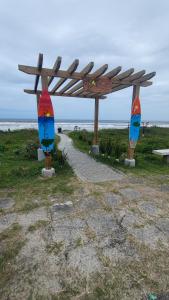 a wooden bench with two surfboards sitting next to the beach at Sobrado com 3 quartos piscina 100m mar em matinhos in Matinhos