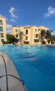 a large swimming pool with people in the water at Appartement résidence Port yasmine hammamet in Hammamet