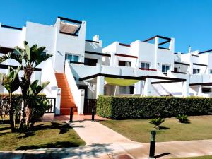 a white building with a palm tree in front of it at Cozy Pool & Golf House at Condado de Alhama 