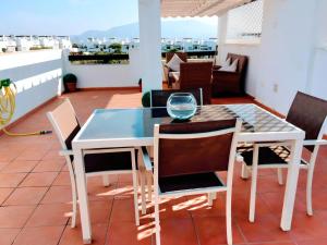 y balcón con mesa de comedor y sillas. en Cozy Pool & Golf House at Condado de Alhama, 