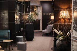 a lobby with chairs and plants in a room at Interhotel Tatra in Kopřivnice