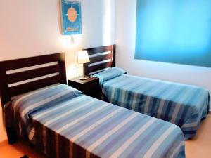 Dos camas en una habitación de hotel con dos en Cozy Pool & Golf House at Condado de Alhama, 