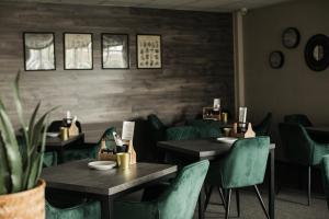 a dining room with tables and green chairs at Interhotel Tatra in Kopřivnice