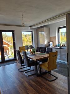 uma cozinha e sala de jantar com mesa e cadeiras em Vila Lac em Brasov