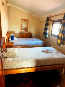 Un dormitorio con dos camas y un espejo. en SwordFish Ocean View House, en Peniche