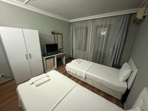 a hotel room with two beds and a desk at Akkent Garden Hotel in Fethiye