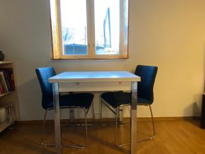 a table with four chairs in a room with a window at Apartment Brevik in Brevik