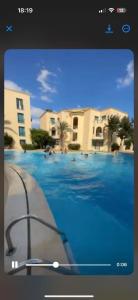 a picture of a swimming pool in front of a building at Appartement résidence Port yasmine hammamet in Hammamet