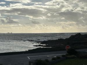 a stop sign on a road next to the ocean at TI YANN in Porspoder +5 photos