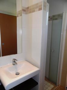 La salle de bains blanche est pourvue d'un lavabo et d'un miroir. dans l'établissement VVF Haute Loire Haute Ardèche, à Tence