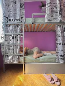 a person laying on a bunk bed with newspapers at Pechersky Hostel in Kyiv