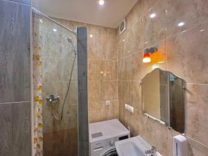 ein Bad mit einer Dusche, einem Waschbecken und einem Spiegel in der Unterkunft Pechersky Hostel in Kiew
