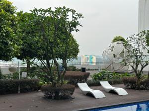 2 chaises blanches et un arbre dans un bâtiment dans l'établissement Educity Legoland Eco Botanic Homestay, à Johor Bahru