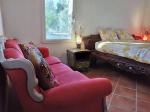 Loft Carriones في Castilléjar: غرفة معيشة مع كرسيين حمر وسرير