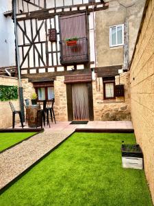 an external view of a house with a green lawn at Apartamentos Mikaela in El Burgo de Osma