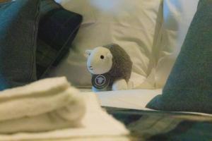 un animale di peluche seduto sopra un letto di The Mardale Inn a Penrith