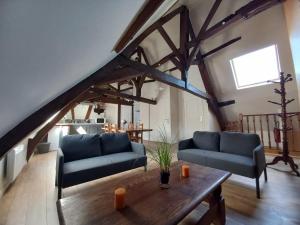 a living room with blue couches and a wooden table at Le gîte des Géants in Le Quesnoy