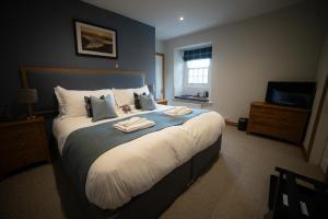 a bedroom with a large bed with towels on it at The Mardale Inn in Penrith