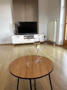 una copa de vino sentada en una mesa frente a una TV en Gehobene Ferienwohnung Madera Campesina, en Hunderdorf