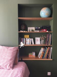 półka z książkami obok łóżka w obiekcie Le bois de mon coeur - studio cosy indépendant 