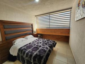 ein Schlafzimmer mit einem Bett und einem großen Fenster in der Unterkunft Confortante departamento con Pkg Privado in Guadalajara