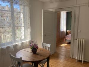 een kamer met een tafel en stoelen en een raam bij Le bois de mon coeur - studio cosy indépendant 