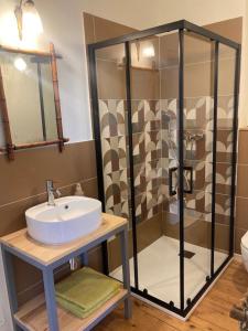 a bathroom with a sink and a shower at Le bois de mon coeur - studio cosy indépendant 