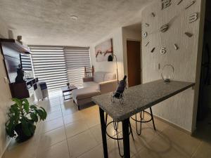 ein Wohnzimmer mit einem Tisch und einem Sofa in der Unterkunft Confortante departamento con Pkg Privado in Guadalajara