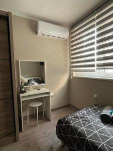 - une chambre avec un lit et un bureau avec un miroir dans l'établissement Apartman Petrov, à Donji Milanovac
