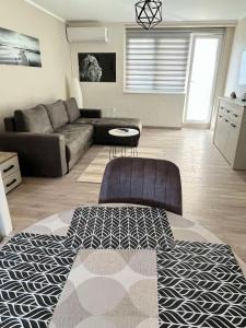 ein Wohnzimmer mit einem Sofa und einem Tisch in der Unterkunft Apartman Petrov in Donji Milanovac