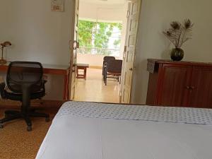 a bedroom with a bed and a desk and a chair at Srinekatan Heritage Villa Homestay in Ahmedabad
