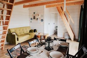 a living room with a couch and a table and chairs at Folwark Soblówka - Domek AGAT z sauną i widokiem na góry in Sablówka