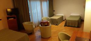 a room with two beds and a table and chairs at Solofra Palace Hotel & Resort in Solofra