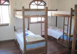 Diamantina Ecohostel في ديامانتينا: غرفة مع ثلاثة أسرة بطابقين في منزل