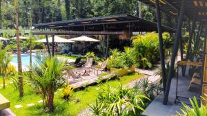 un patio con piscina, mesas y sombrillas en Exôtico Beach Hotel, en Puerto Viejo