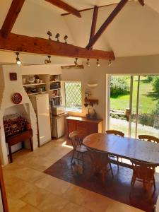 a kitchen with a table and a dining room at Stable Lodge B&B in Petham