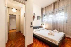 1 dormitorio con cama y ventana grande en Duomo 5 minutes - Elegant with Wifi and Netflix en Milán