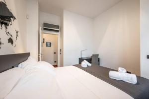 sypialnia z dużym białym łóżkiem z 2 ręcznikami w obiekcie Duomo 5 minutes - Elegant with Wifi and Netflix w Mediolanie